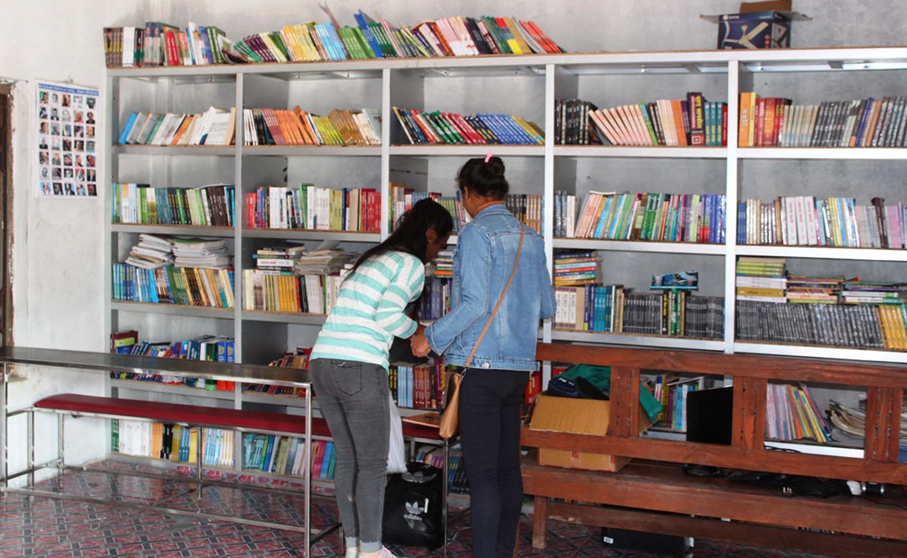 पुस्तकालयमा किताब छान्दै छात्रा